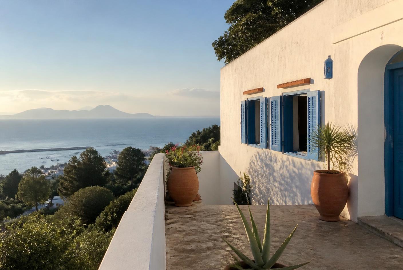 Witgepleisterde woning in Tanger met blauwe luiken en terras met uitzicht op zee